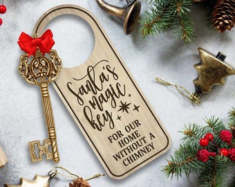 May include: Wooden door hanger with the text "Santa's Magic Key" and a decorative key with a red bow. The key is gold-colored and ornate. The door hanger is light brown with black lettering.