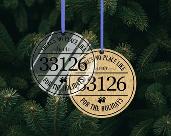 May include: Two Christmas tree decorations. One is clear with a striped design, the other is wood-toned. Both have the text "THERE'S NO PLACE LIKE home FOR THE HOLIDAYS" and the number "33126".