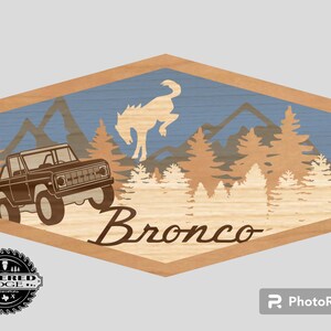 May include: A wooden sign with a blue and brown mountain scene, a silhouette of a horse, and a vintage Ford Bronco driving through the forest. The sign reads "Bronco" in a brown script font.