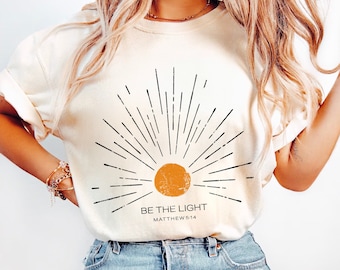 Be The Light Mathew 5 14 サンバースト ヴィンテージ 聖書の一節 クリスチャン 天体 コンフォートカラー Tシャツ、ボヘミアンシャツ、サンシャツ、インスピレーションギフト