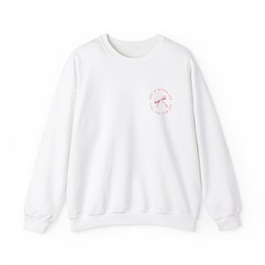 May include: White sweatshirt with a pink ribbon design and the text "God is within me, I will not fear" on the front.