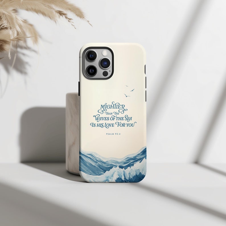 May include: A white phone case with a blue and white ocean wave design. The text "MIGHTER THAN THE WAVES OF THE SEA IS HIS LOVE FOR YOU" is printed on the case, along with the verse "PSALM 93:4".