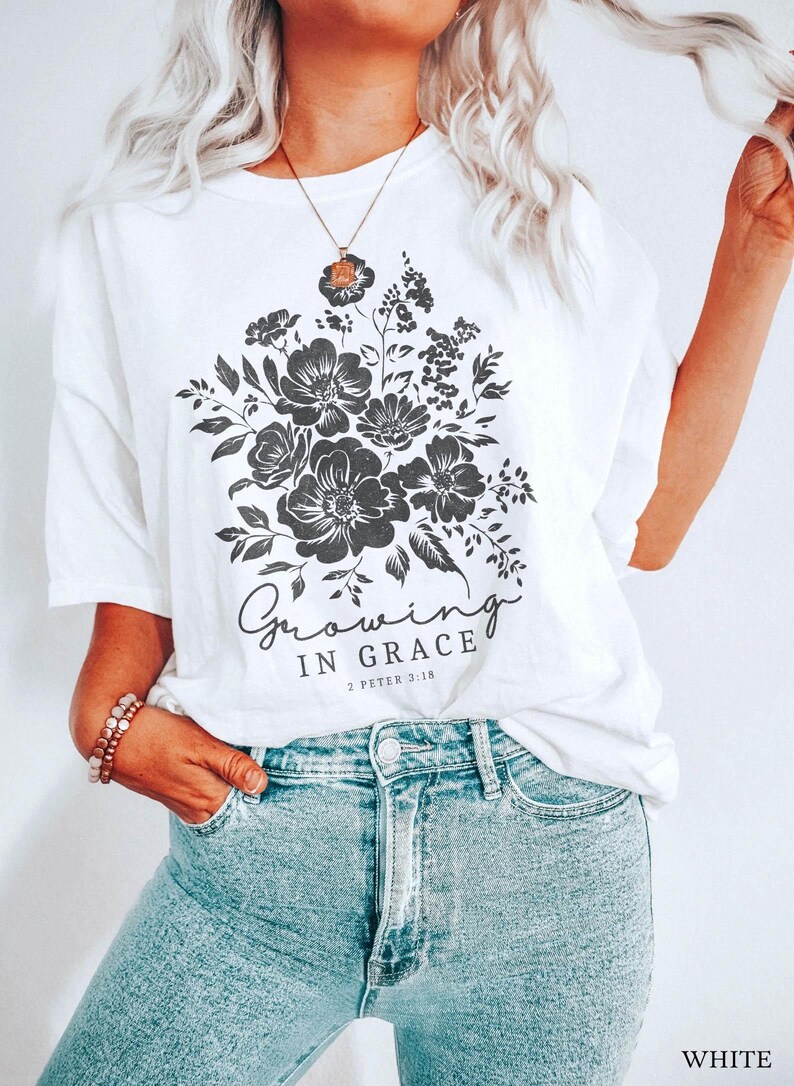 May include: White t-shirt with a black floral design and the text "Growing in Grace 2 Peter 3:18".