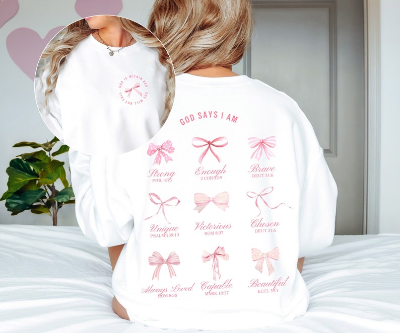 May include: White sweatshirt with pink bows and the text "GOD SAYS I AM" with bible verses listed below each bow.