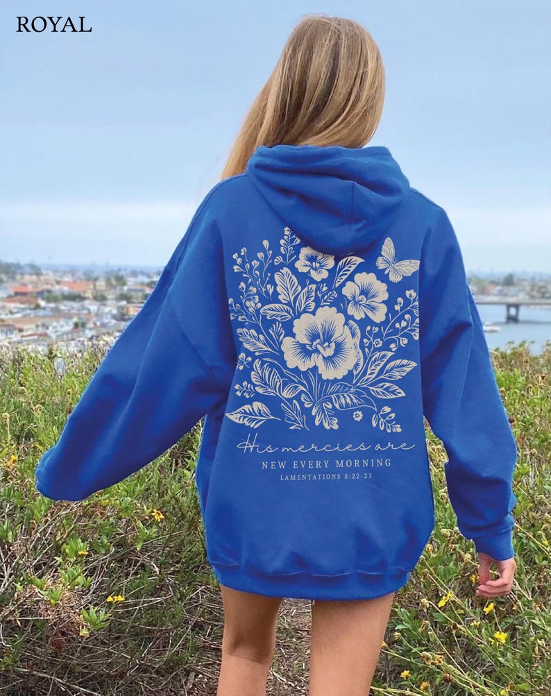 May include: A royal blue hoodie with a white floral design and the text "His mercies are new every morning - Lamentations 3:22-23" on the back.