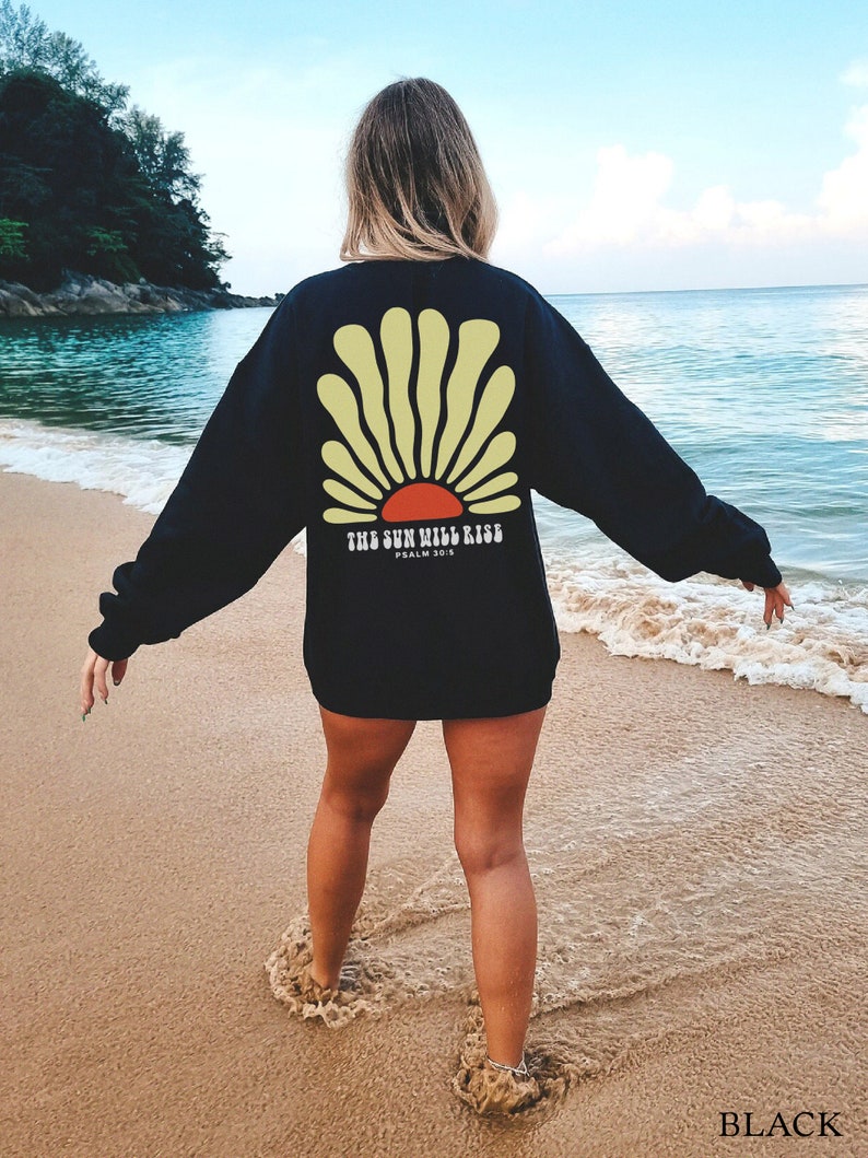 May include: Black sweatshirt with a yellow and red sun graphic and the text "THE SUN WILL RISE, PSALM 30:5".