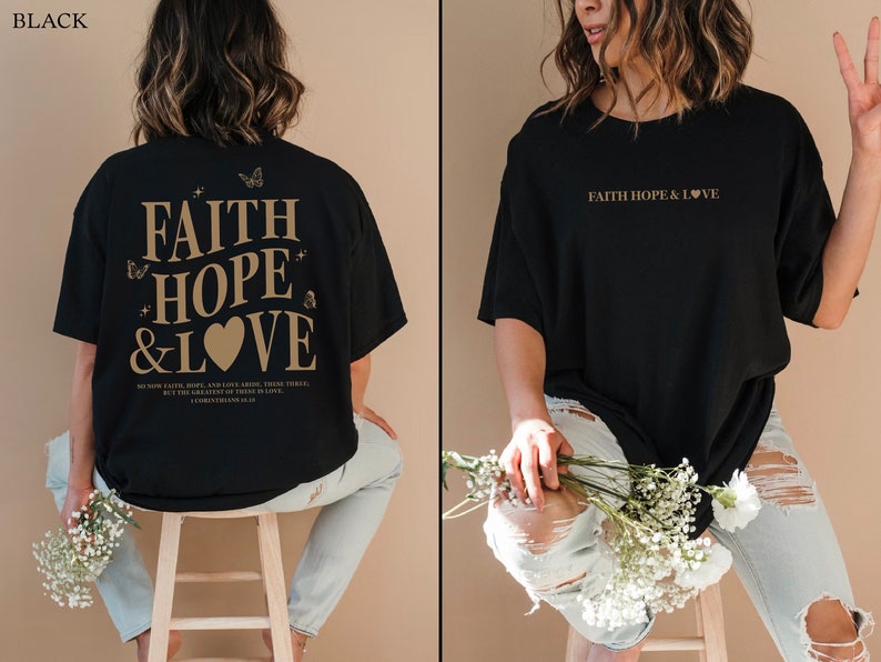 May include: Black oversized t-shirt with the text "FAITH HOPE & LOVE" in gold lettering on the front and back. The back also includes a small heart and butterflies. The shirt is being modeled by a person wearing light blue jeans.
