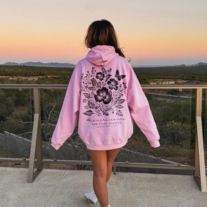 May include: A light pink hoodie with a black floral design and the text "His mercies are new every morning" on the back.