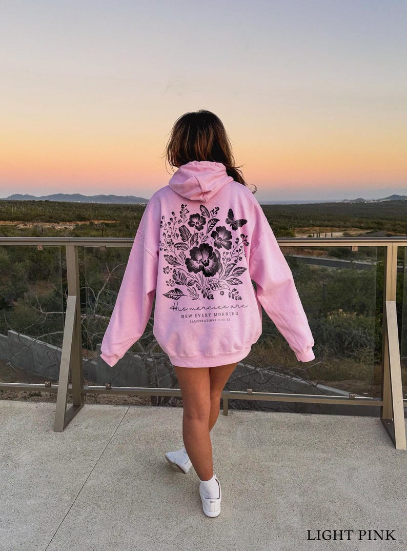 May include: A light pink hoodie with a black floral design and the text "His mercies are new every morning" on the back.