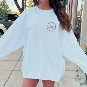 May include: A white sweatshirt with a graphic print of a mountain range and the text "So I will praise you on the mountain".