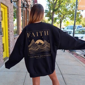 May include: Black sweatshirt with a gold graphic of mountains and a sun with the text "FAITH CAN MOVE MOUNTAINS MATTHEW 17:20"