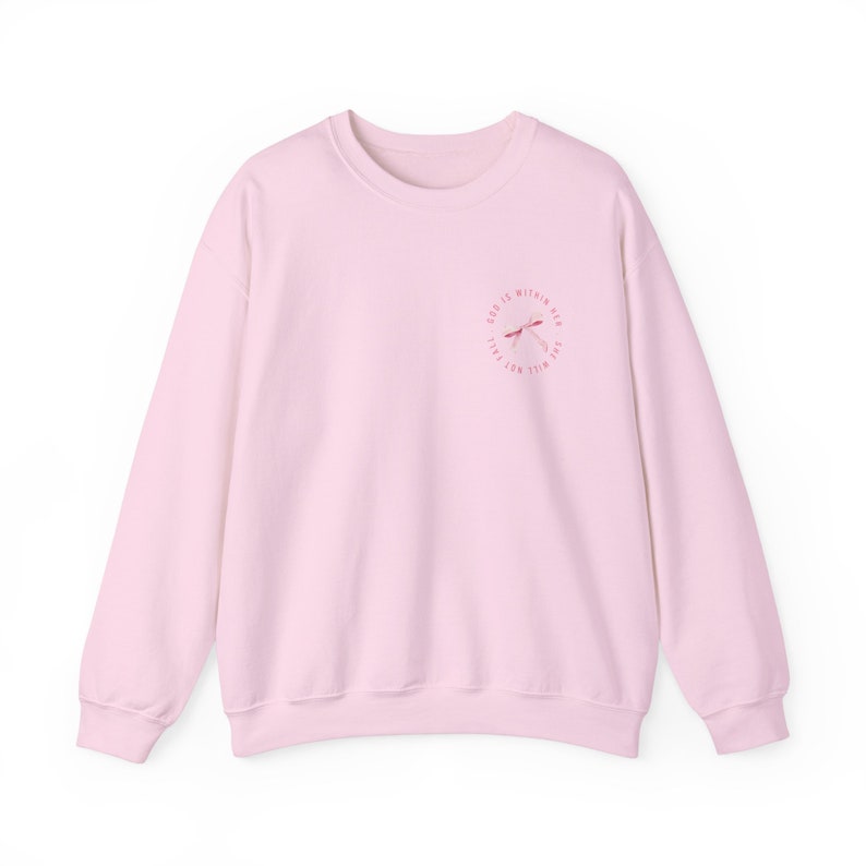May include: A pink sweatshirt with a pink and white graphic design on the front. The graphic design features a dragonfly and the text "God is within me, I will not fall".