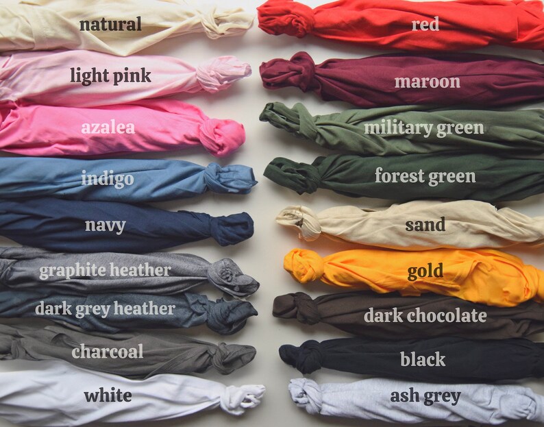 May include: A collection of folded t-shirts in various colors, including natural, light pink, azalea, indigo, navy, graphite heather, dark grey heather, charcoal, white, red, maroon, military green, forest green, sand, gold, dark chocolate, black, and ash grey.