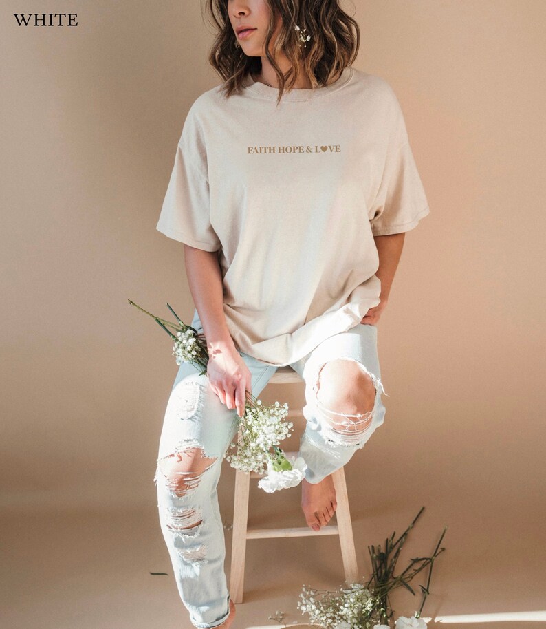 May include: A beige oversized t-shirt with the text "FAITH HOPE & LOVE" and a small heart symbol printed on the front.
