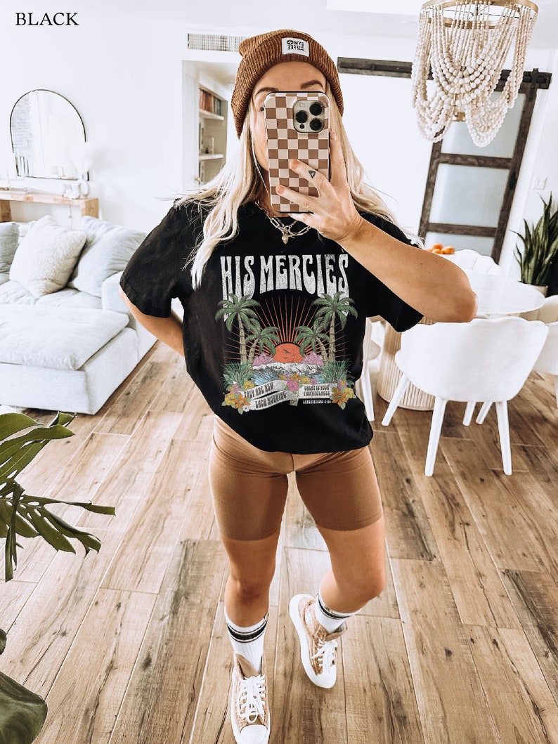 May include: Black t-shirt with a graphic print of a sunset with palm trees and the text "His Mercies". The graphic also includes the text "New For You" and "Lord Spring".
