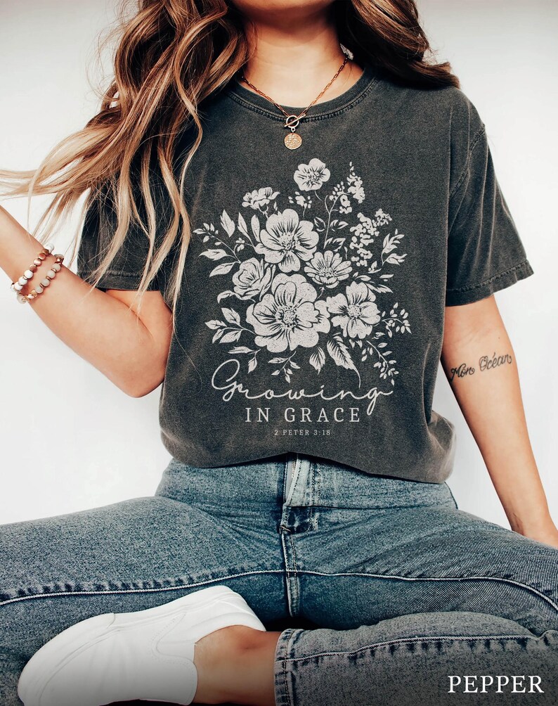 May include: A dark gray t-shirt with a floral design and the text "Growing in Grace 2 Peter 3:18".