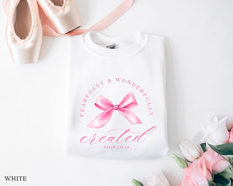 May include: White sweatshirt with a pink bow and the text "Fearfully & Wonderfully created Psalm 139:14" printed on the front.