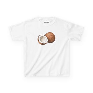 May include: A white short-sleeved t-shirt featuring a graphic of a whole brown coconut and a halved coconut with white flesh. The inner collar area displays the text Lucky Angels in black print on a white background.