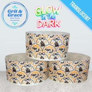 Può includere: Tre accessori traslucidi per bottiglie d'acqua con un design a tema Halloween. Il design presenta pipistrelli neri, castelli e dettagli arancioni su sfondo bianco. Il testo "Glow in the Dark" è visibile.