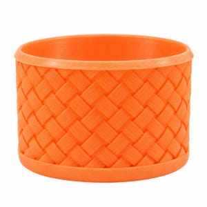 May include: A bright orange cylindrical container featuring a textured exterior with a woven basket-weave pattern. The vessel has a smooth, solid rim at the top and a matching solid base, creating a uniform and consistent appearance throughout.