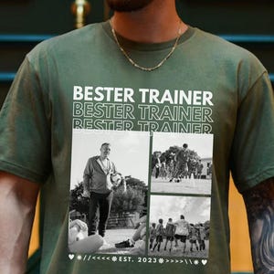 May include: An olive green t-shirt with the text "BESTER TRAINER" repeated above a collage of black and white photos. The shirt has a crew neck and short sleeves. The text "EST. 2023" is also printed on the shirt.