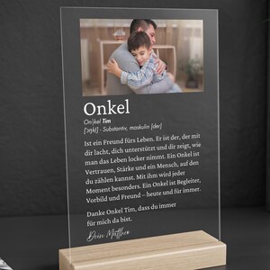 May include: A clear acrylic plaque with a photo of a man hugging a child, set on a light wood base. The plaque features German text, including the word "Onkel" and a dedication.