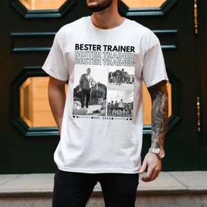May include: White t-shirt with the text "BESTER TRAINER" repeated. The shirt has a black and white collage of images, including a person with a ball and a group of people. The text "EST. 2023" is also present.