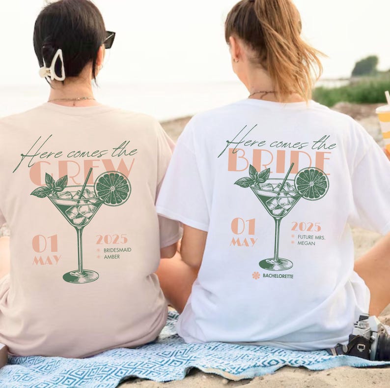 May include: Two white t-shirts with a green and orange cocktail graphic. The text on the shirts reads "Here comes the crew" and "Here comes the bride". The shirts also include the date "01 May 2025" and the text "Bridemaid Amber" and "Future Mrs. Megan".