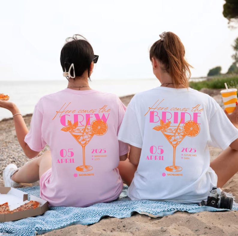 May include: Two t-shirts, one pink and one white, with a cocktail graphic and the text "Here Comes the Crew" and "Here Comes the Bride". The shirts also display the date "05 April 2025" and the word "Bachelorette".