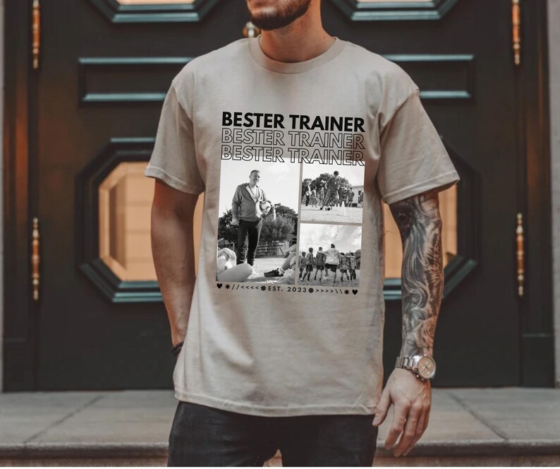 May include: Beige t-shirt with the text "BESTER TRAINER" repeated three times in black. The shirt features a collage of black and white photos. The shirt is a crew neck and has short sleeves.