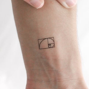 Könnte beinhalten: Eine kleine, schwarze Linienzeichnung des goldenen Schnitts, auch bekannt als Fibonacci-Spirale, ist auf das Handgelenk einer Person tätowiert.