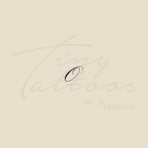 Può includere: Un tatuaggio temporaneo nero con la lettera "O" in corsivo. Il tatuaggio misura 1,3 cm per 3,3 cm. Le parole "Tiny Tattoos" sono scritte in corsivo marrone chiaro sopra la lettera. Le parole "by tatteco" sono scritte in corsivo marrone chiaro sotto.