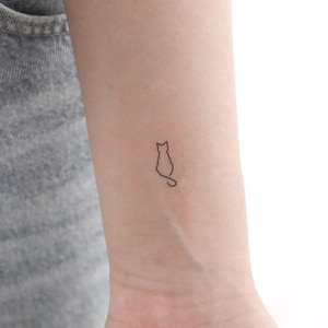 Könnte beinhalten: Eine einfache Linienzeichnung eines sitzenden Katzes mit einem um den Körper gewickelten Schwanz.