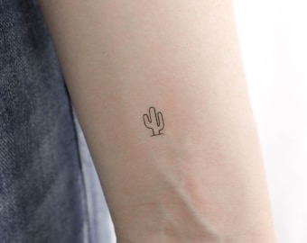 May include: A simple line drawing tattoo of a cactus on a person's wrist.