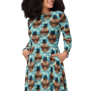 May include: A blue dress with a pattern of brown bears wearing top hats. The dress has long sleeves and a flared skirt.