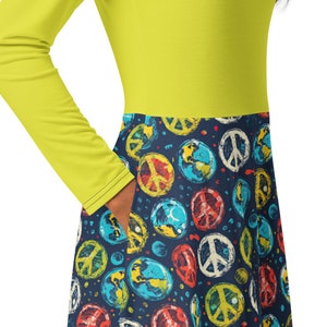 May include: A yellow long-sleeved dress with a blue and white peace sign and globe print on the skirt.