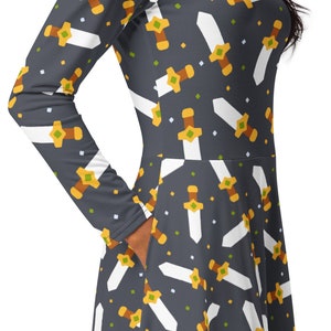 May include: A long-sleeved dress with a dark gray background and a white and yellow repeating pattern of swords.