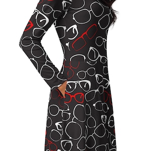 May include: A black long-sleeved dress with a white and red eyeglasses print. The dress has a fitted bodice and a flared skirt.