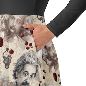 May include: A black long-sleeved dress with a white and cream skirt featuring a repeating pattern of Albert Einstein's face and red splotches.