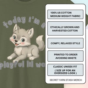 以下が含まれることがあります： オリーブグリーンのTシャツ。漫画のオオカミと「today i'm a playful lil wo」の文字がプリントされています。生地、スタイル、印刷に関する情報が含まれています。クラシックなユニセックスフィットです。