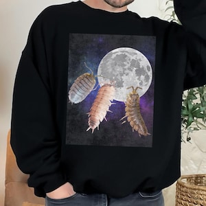 Op de afbeelding: Zwart sweatshirt met een grafische print van drie pissebedden op een donkerblauwe achtergrond met een witte maan. De maan heeft een getextureerd oppervlak.