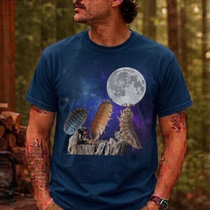 Op de afbeelding: Marineblauw T-shirt met een grafisch ontwerp van drie insecten op een boomstronk, een volle maan en een sterrenhemel achtergrond. De insecten zijn in verschillende tinten bruin, grijs en blauw.
