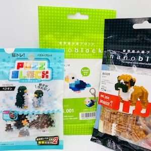 May include: Three packages of micro-sized building block sets. One package features a penguin design, another a bird, and the third a dog. The packages are in blue, green, and black, with Japanese text and images of the finished models.