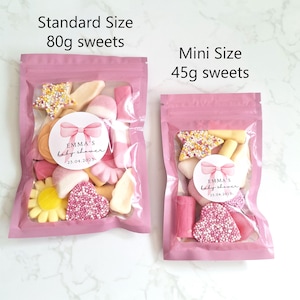 May include: Two pink cellophane bags filled with sweets. The larger bag, labeled "Standard Size," contains 80g of sweets, while the smaller bag, labeled "Mini Size," contains 45g. Each bag has a sticker that reads "EMMA'S baby shower 23.04.2025."