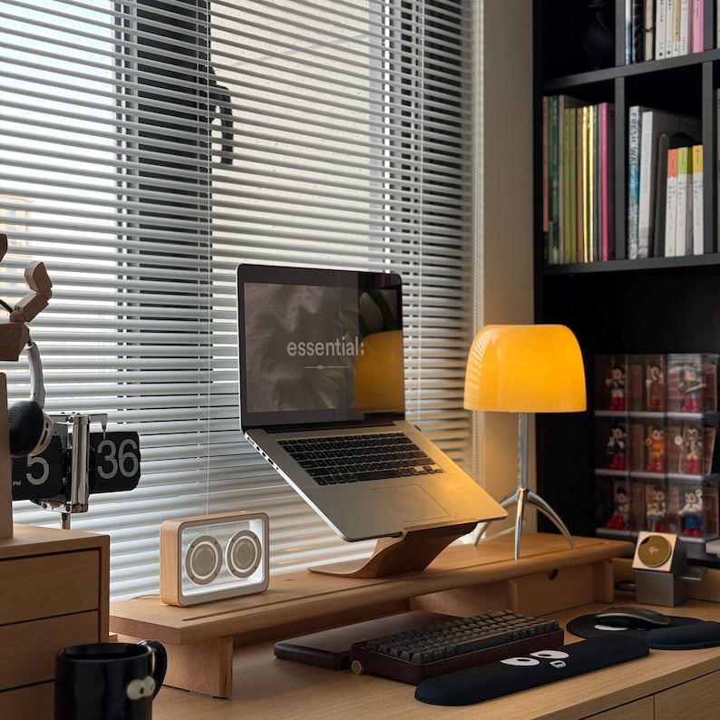 LOOMMA brand walnut wood laptop stand on a desk supporting an Apple MacBook, highlighting durable construction and a sleek design for an enhanced ergonomic workspace