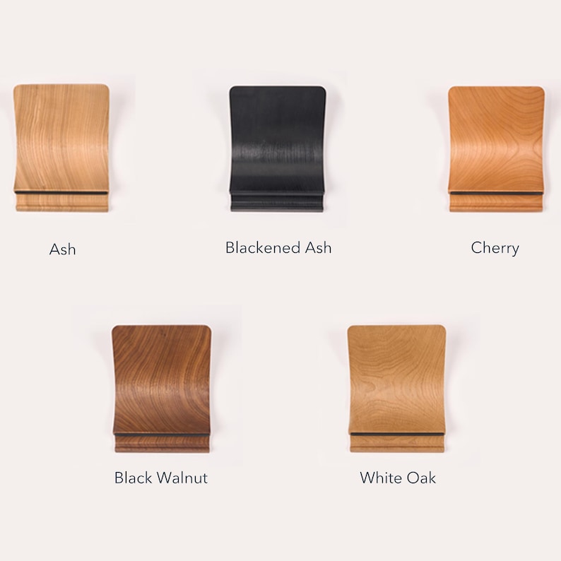 Collection of five LOOMMA laptop stands crafted from distinct woods: light ash, dark stained ash, reddish cherry, deep brown walnut, and pale robust white oak, each showcasing unique grain and color