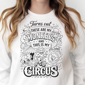 May include: White sweatshirt with a black and white circus-themed graphic. The graphic features monkeys, an elephant, a lion, and the text "Turns out these are my monkeys and this is my circus."