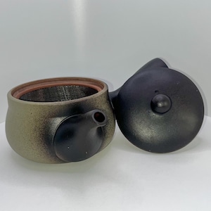May include: A black and green ceramic teapot with a strainer and a black lid. The teapot has a speckled finish and a black handle.