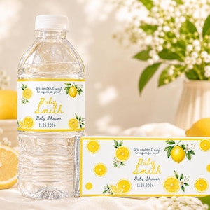 May include: A clear plastic water bottle and a rectangular candy bar, both featuring white labels with yellow lemon illustrations, green leaves, and the text: We couldn't wait to squeeze you! Baby Smith Baby Shower 11.24.2026.