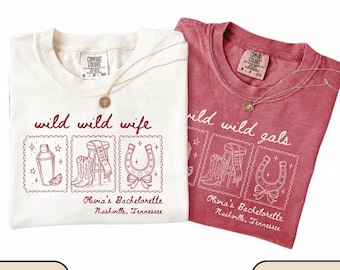Puede incluir: Dos camisetas, marfil y carmesí, con los textos "wild wild wife" y "wild wild gals". Cada camiseta presenta una coctelera, botas de vaquero y un gráfico de herradura. El texto "Olivia's Bachelorette Nashville, Tennessee" también está impreso en las camisetas.